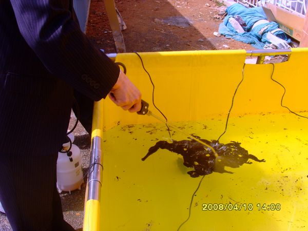 24 Korean Institute officials applying OSE II directly onto the bunker C oil floating on the fresh ocean water in the test container